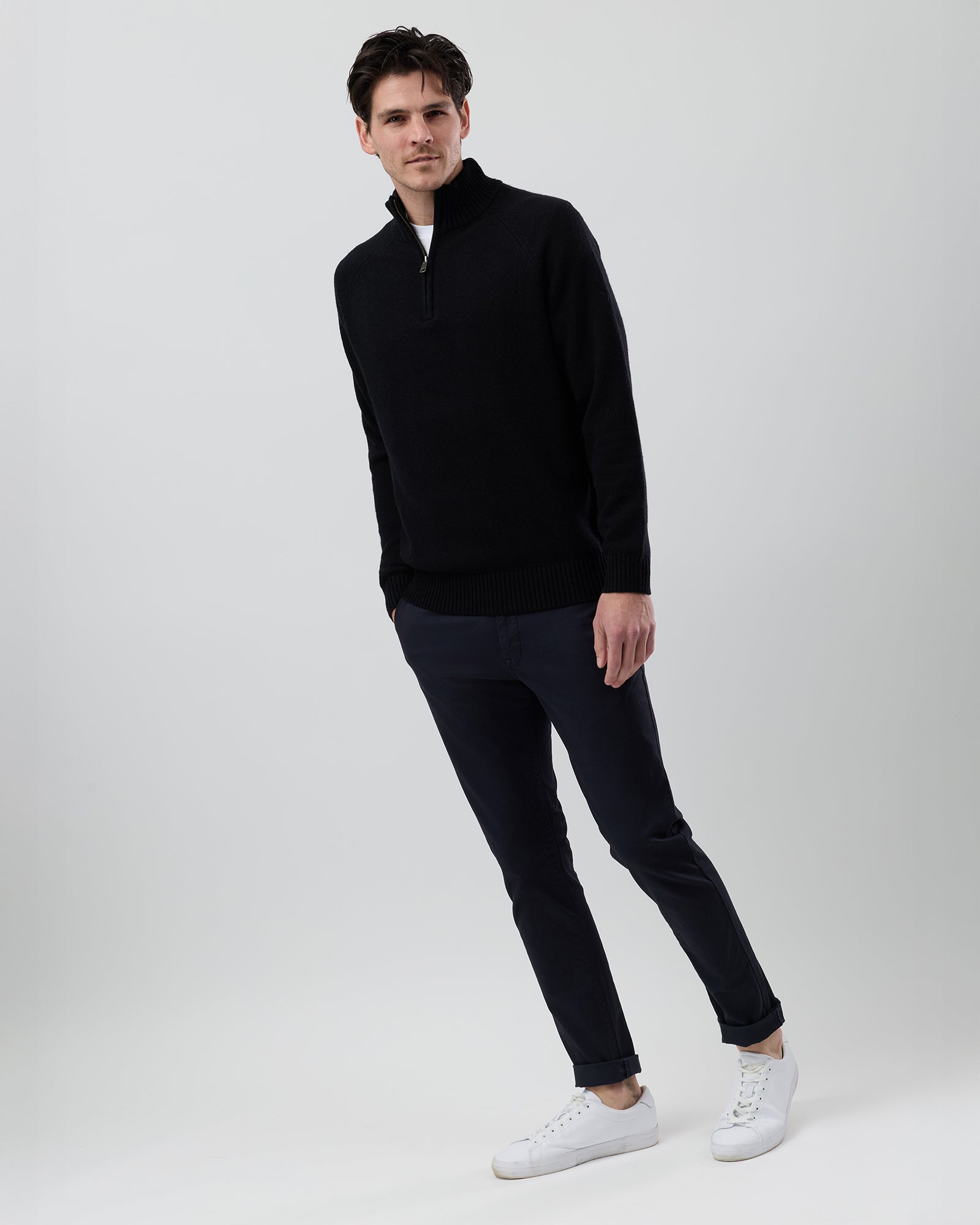 Full-length side profile of a men's black wool blend quarter zip jumper showing the regular fit and slim sleeve shape.