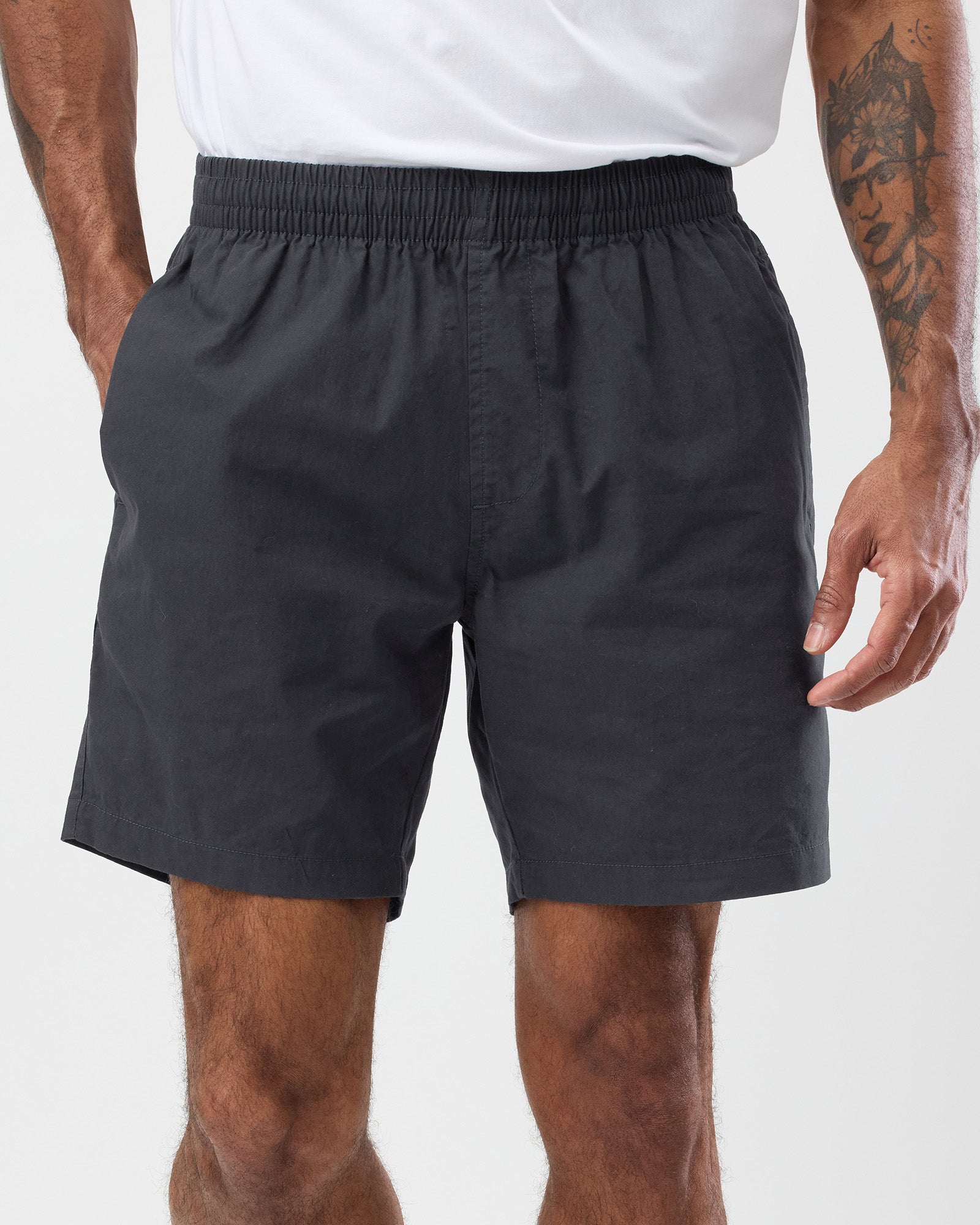 Person wearing black shorts on a plain background