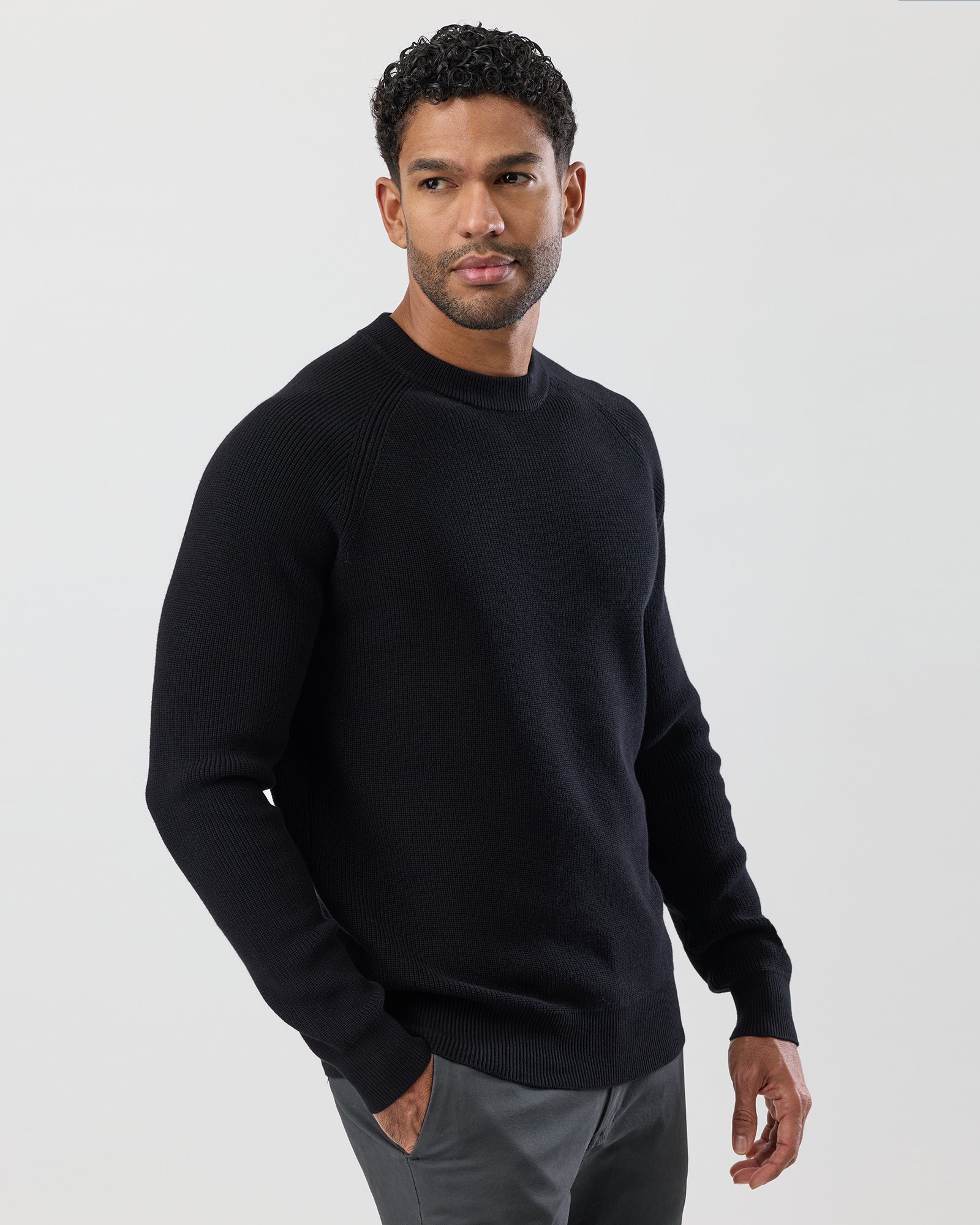 Man wearing a black cotton sweater against a white background