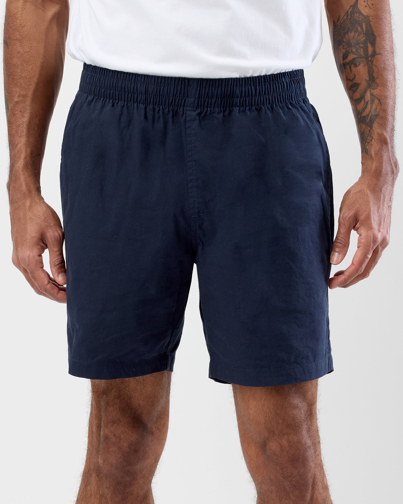A pair of navy blue cotton beach shorts with an elasticated waistband and drawstring, displayed against a white background.