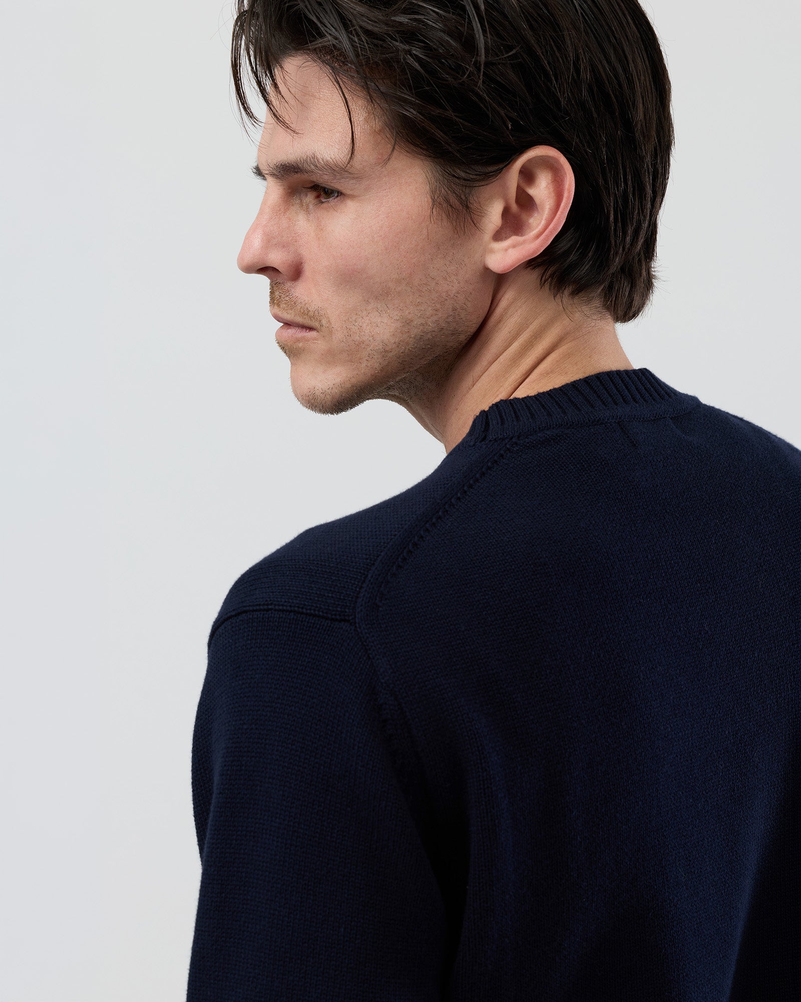 Close-up rear detail of the Wayver navy cotton crew neck knit showing the 2x2 rib detailing at the neckline and shoulder area.