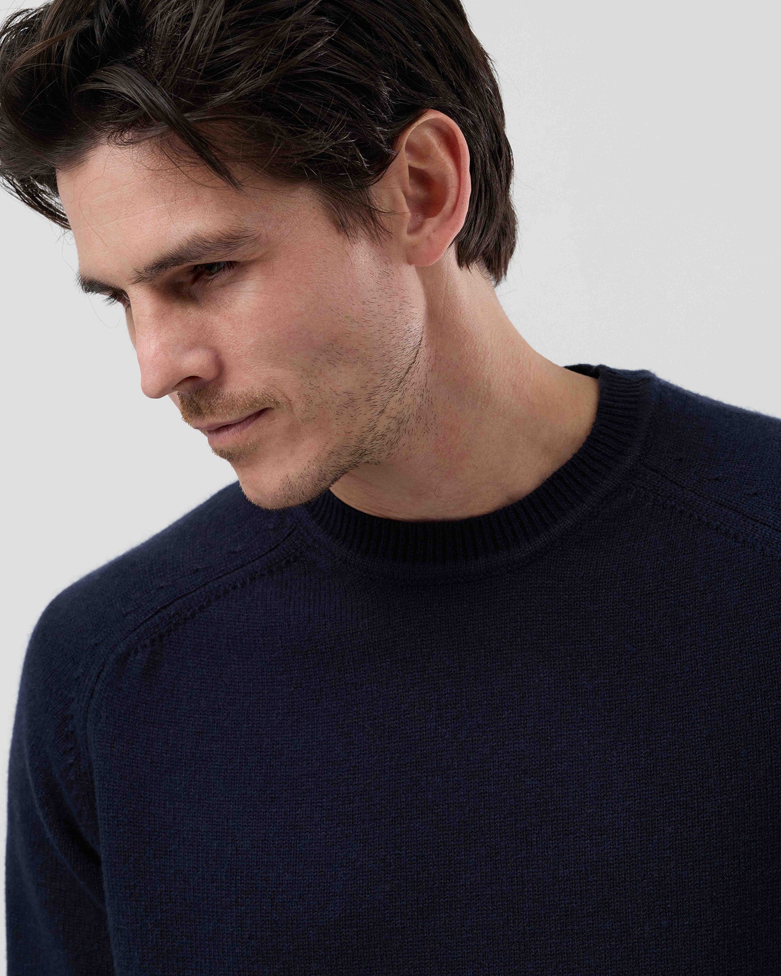 Close-up front view of a men's navy wool blend crew neck sweater highlighting the premium knit texture and refined finish.
