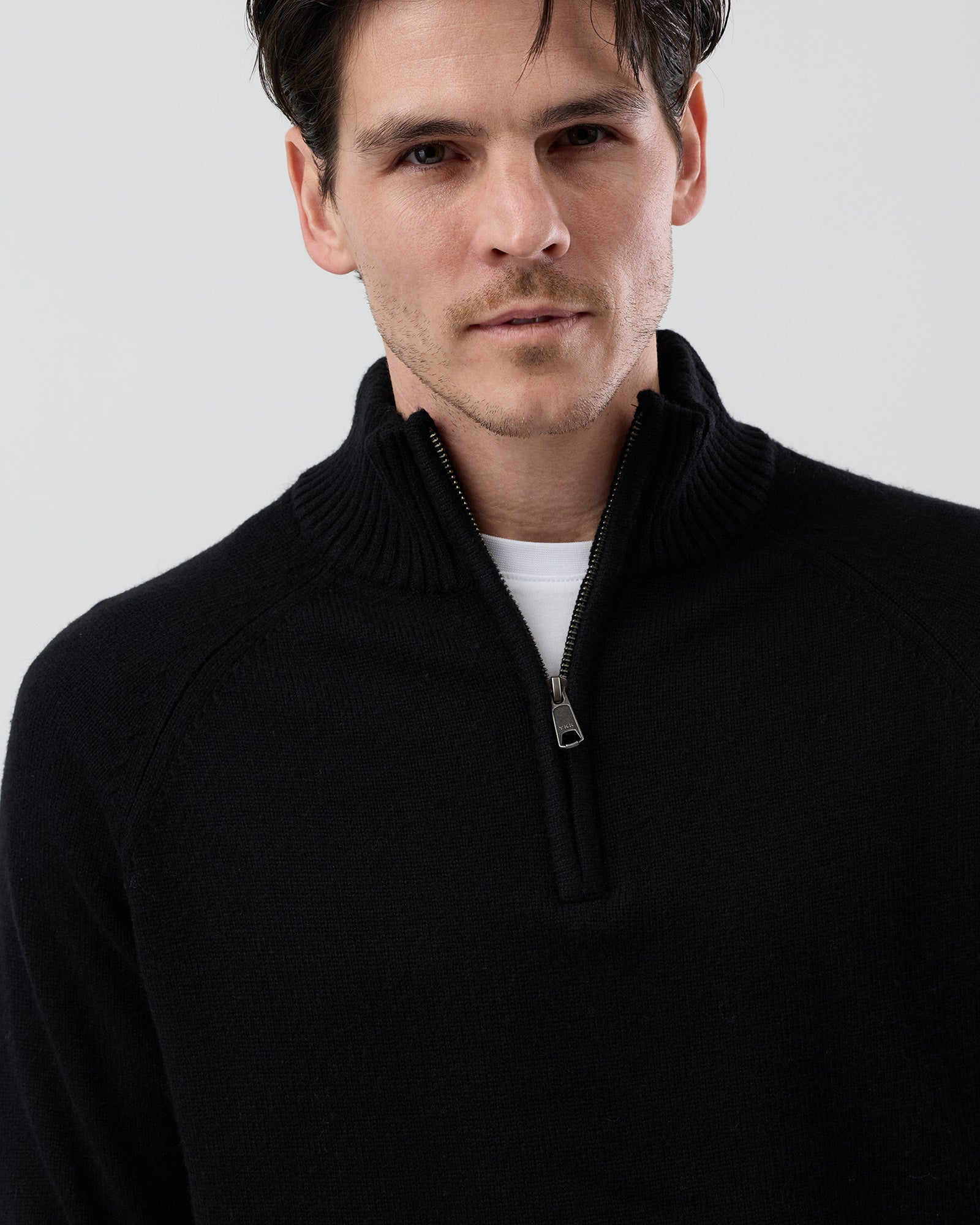 Close-up front view of the Wayver black wool blend half zip knit showing the YKK metal zip, stand collar and premium wool blend texture.