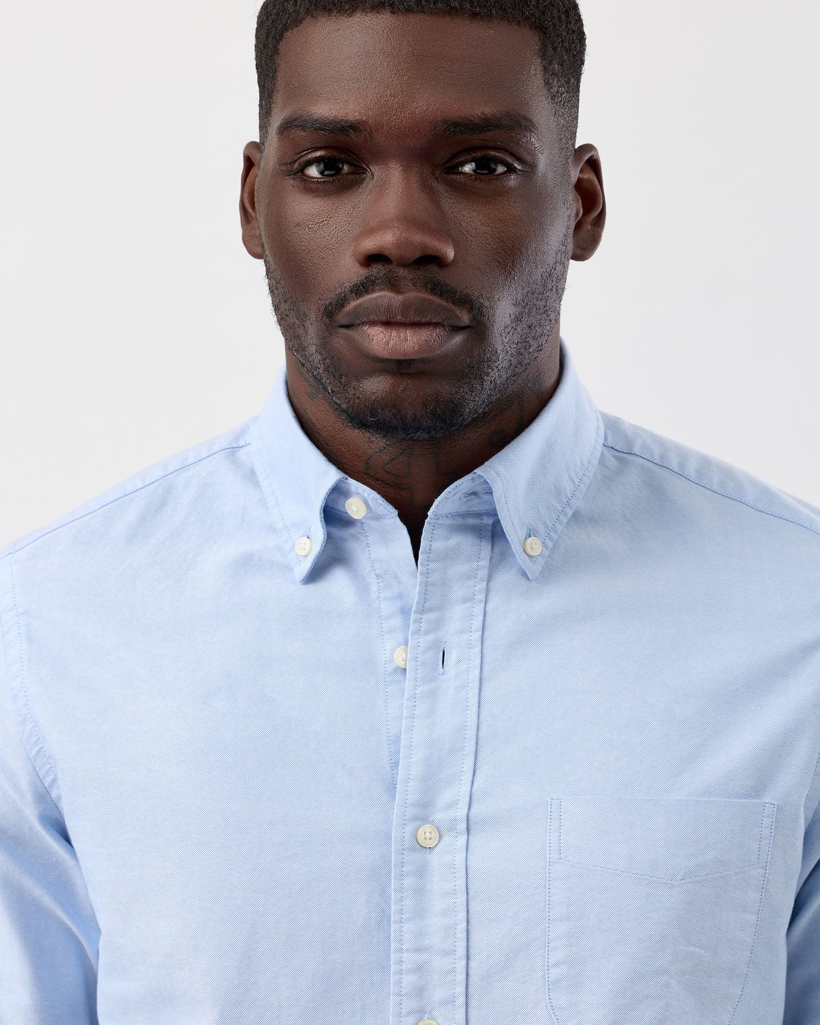 Close up image of a model wearing light blue button-down oxford cotton shirt, from wayver originals