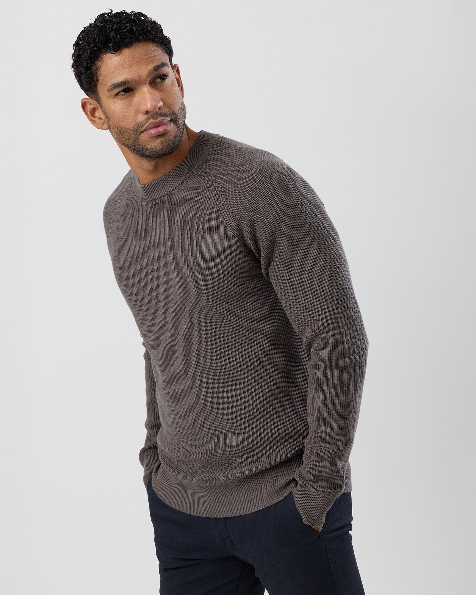 Man wearing a brown sweater against a white background