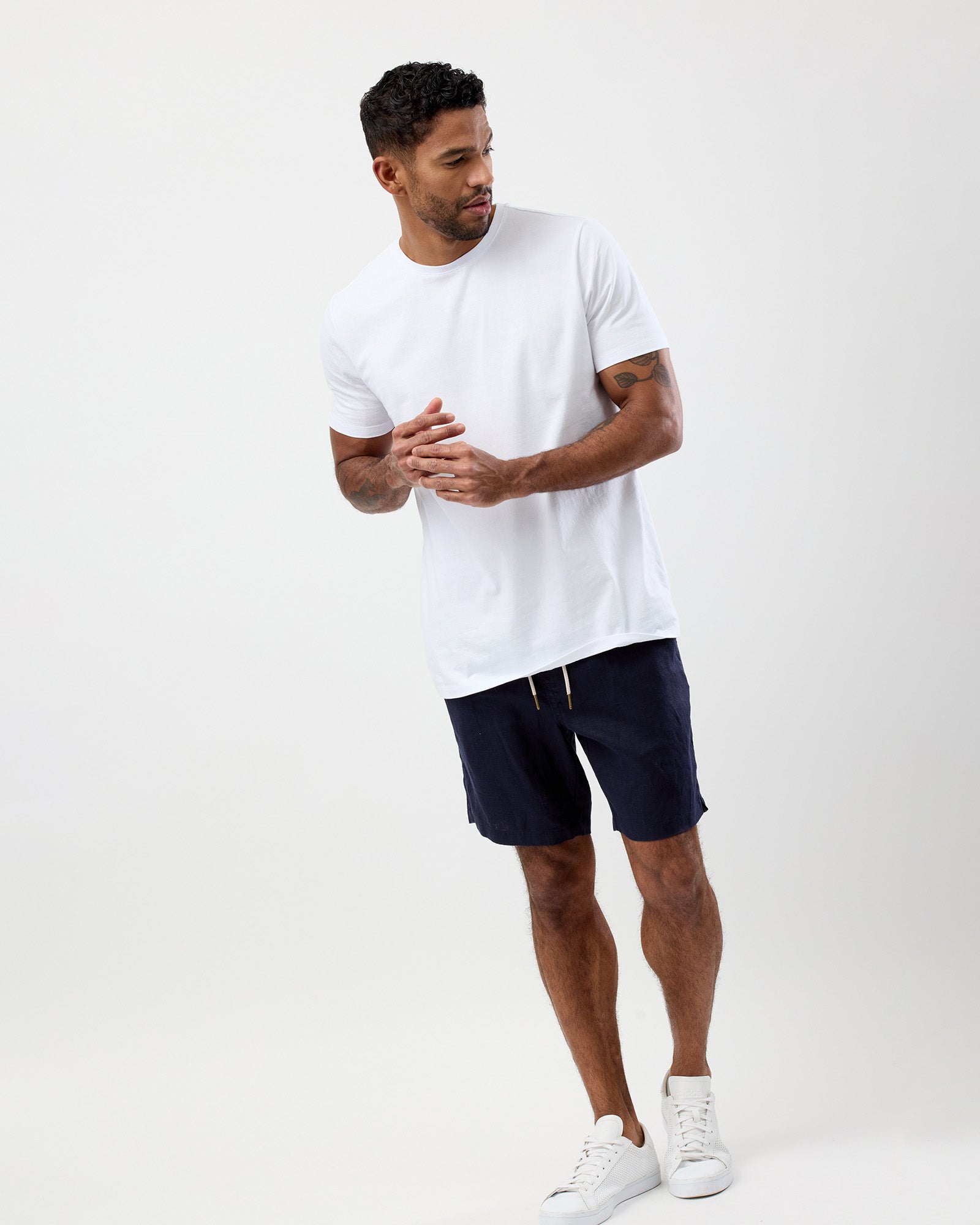 Men's navy linen shorts worn with a white T-shirt showing the relaxed fit, by wayver