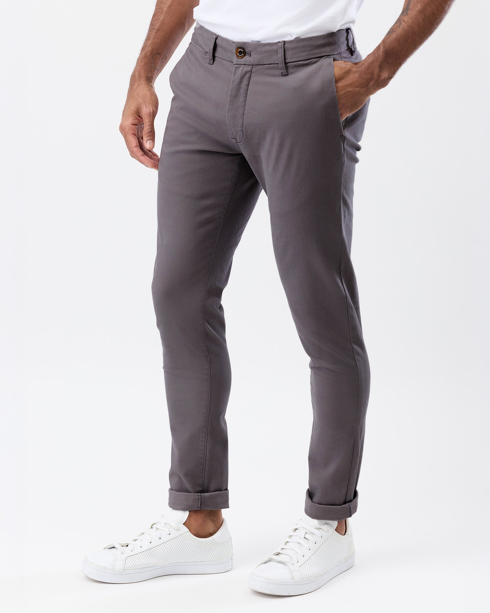Angled view of men's smoke grey stretch chino pants showing the slim fit, side pockets and tapered leg silhouette.