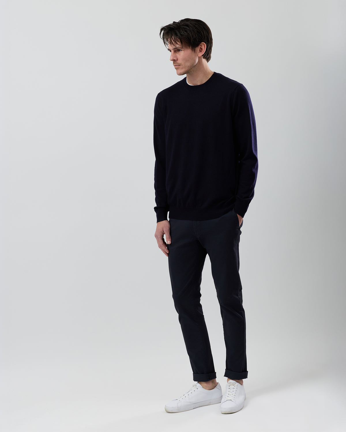 Full-length side profile of a men's navy Australian ultrafine merino wool knit paired with navy chinos on a grey background.