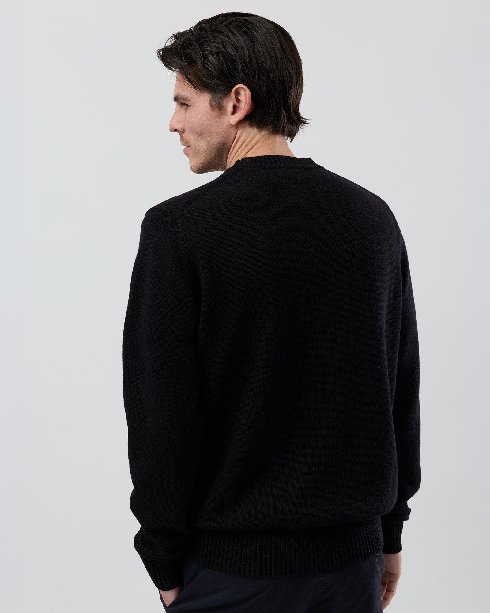Rear view of the Wayver black cotton crew neck knit showing the classic shape and refined knit construction.
