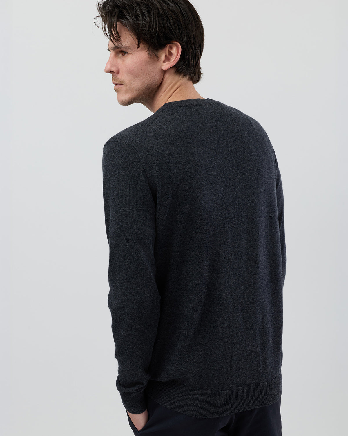 Rear view of a men's charcoal marl Australian ultrafine merino wool knit showing the clean back fit and crew neck design.