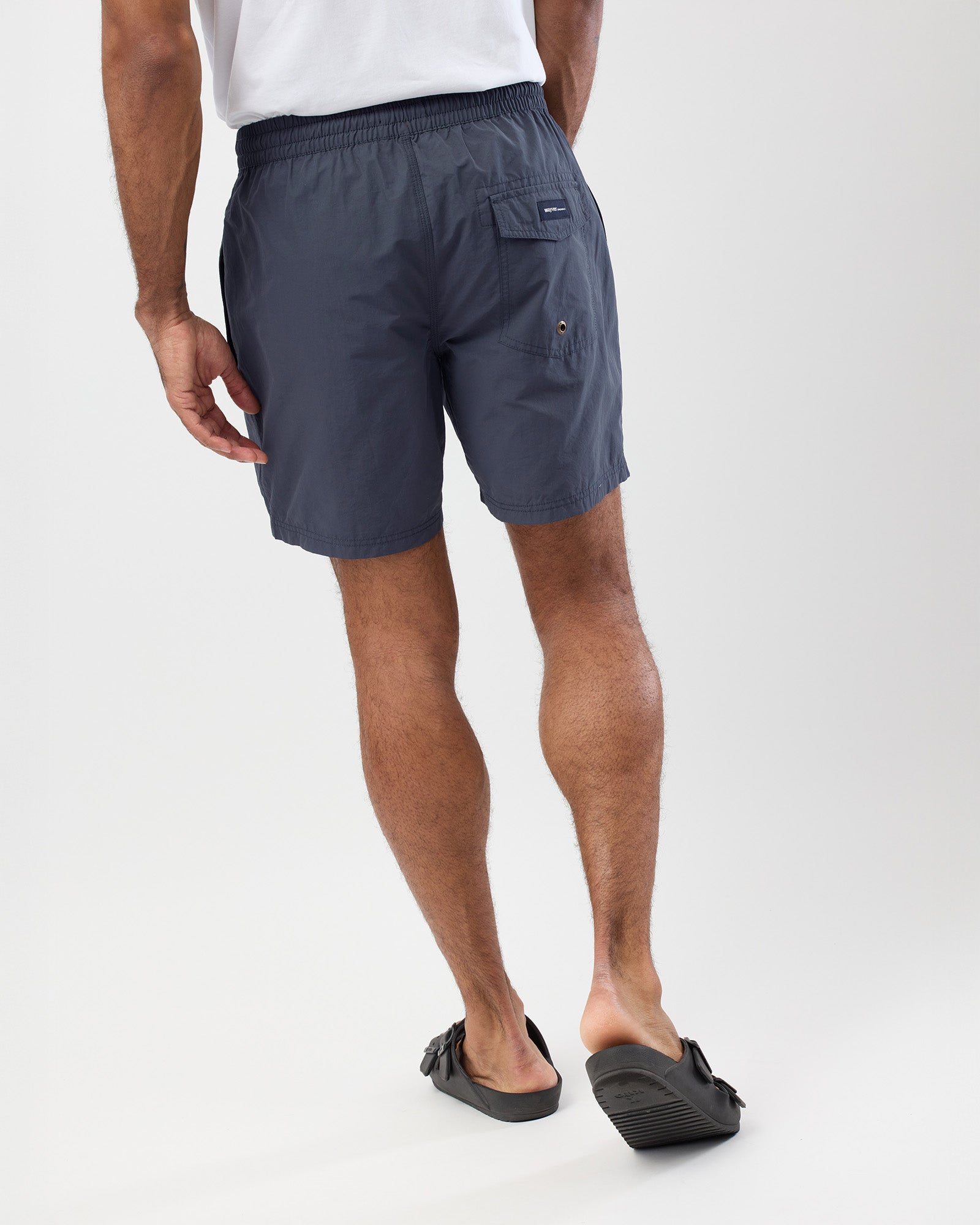 Person wearing men's vintage blue shorts on a white background, rear view