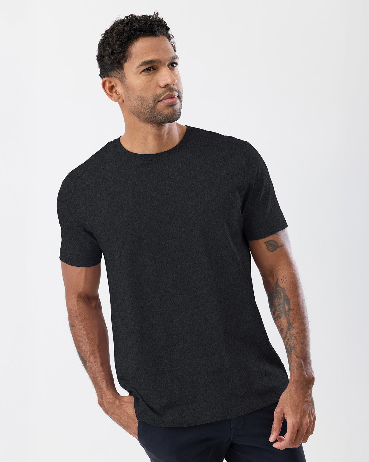 Man wearing a dark charcoal t-shirt against a white background