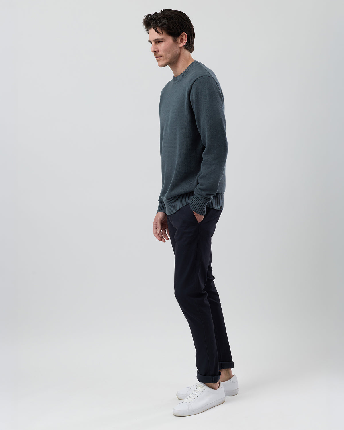 Side profile of a male model wearing the Wayver ironstone cotton crew neck jumper showing the modern regular fit and slim sleeves.