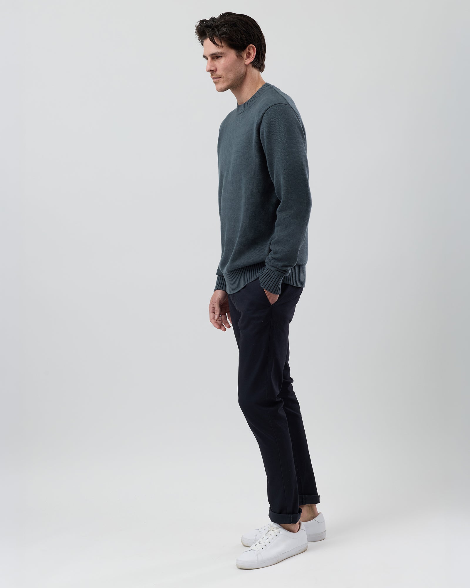 Side profile of a male model wearing the Wayver ironstone cotton crew neck jumper showing the modern regular fit and slim sleeves.