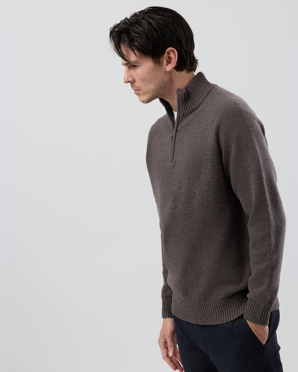 Angled side view of a men's brown marl wool blend quarter zip knit showing the textured marl yarn, refined silhouette and premium jersey knit construction.