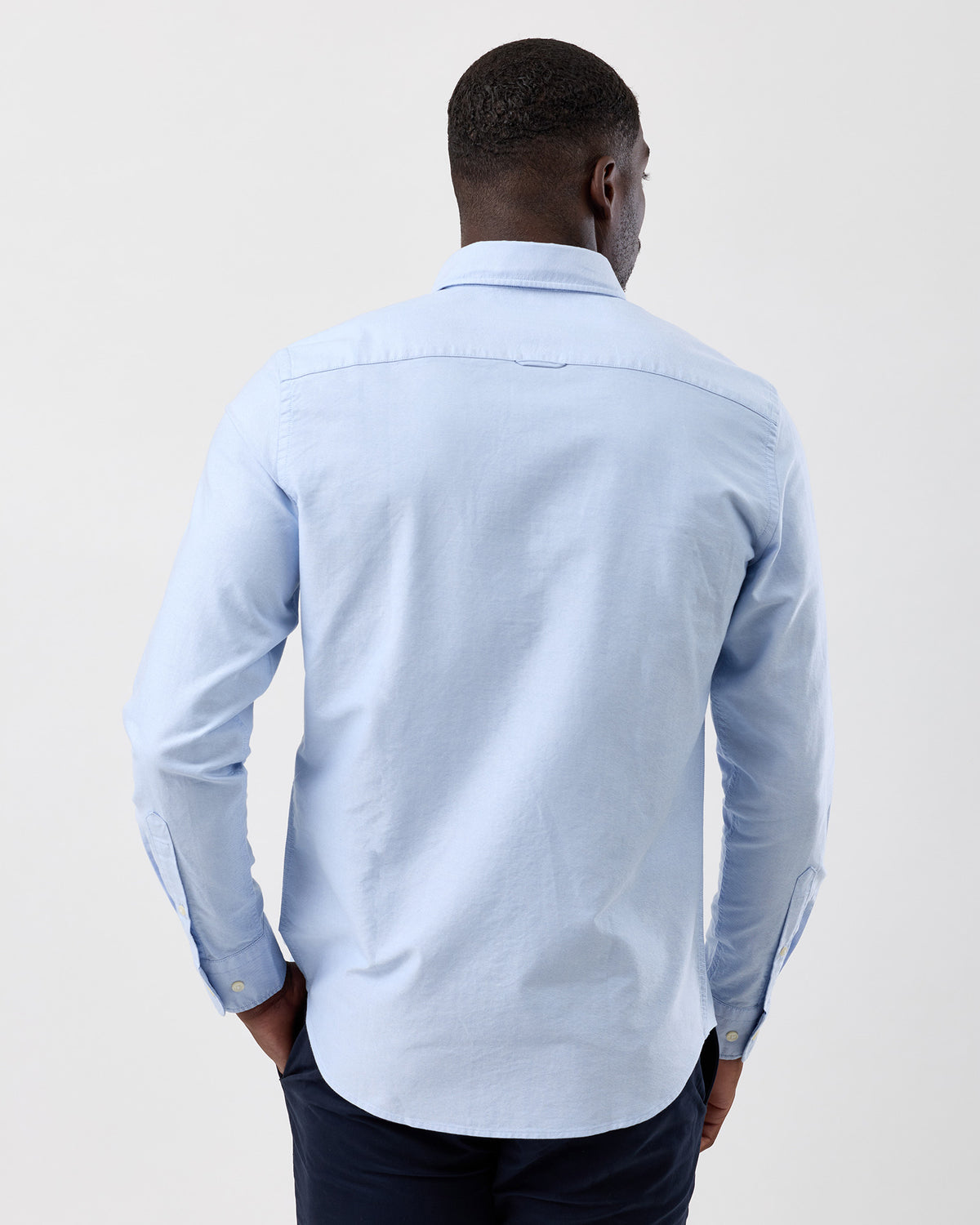Man wearing a casual long sleeve cotton oxford shirt in light blue by wayver originals, rear shot