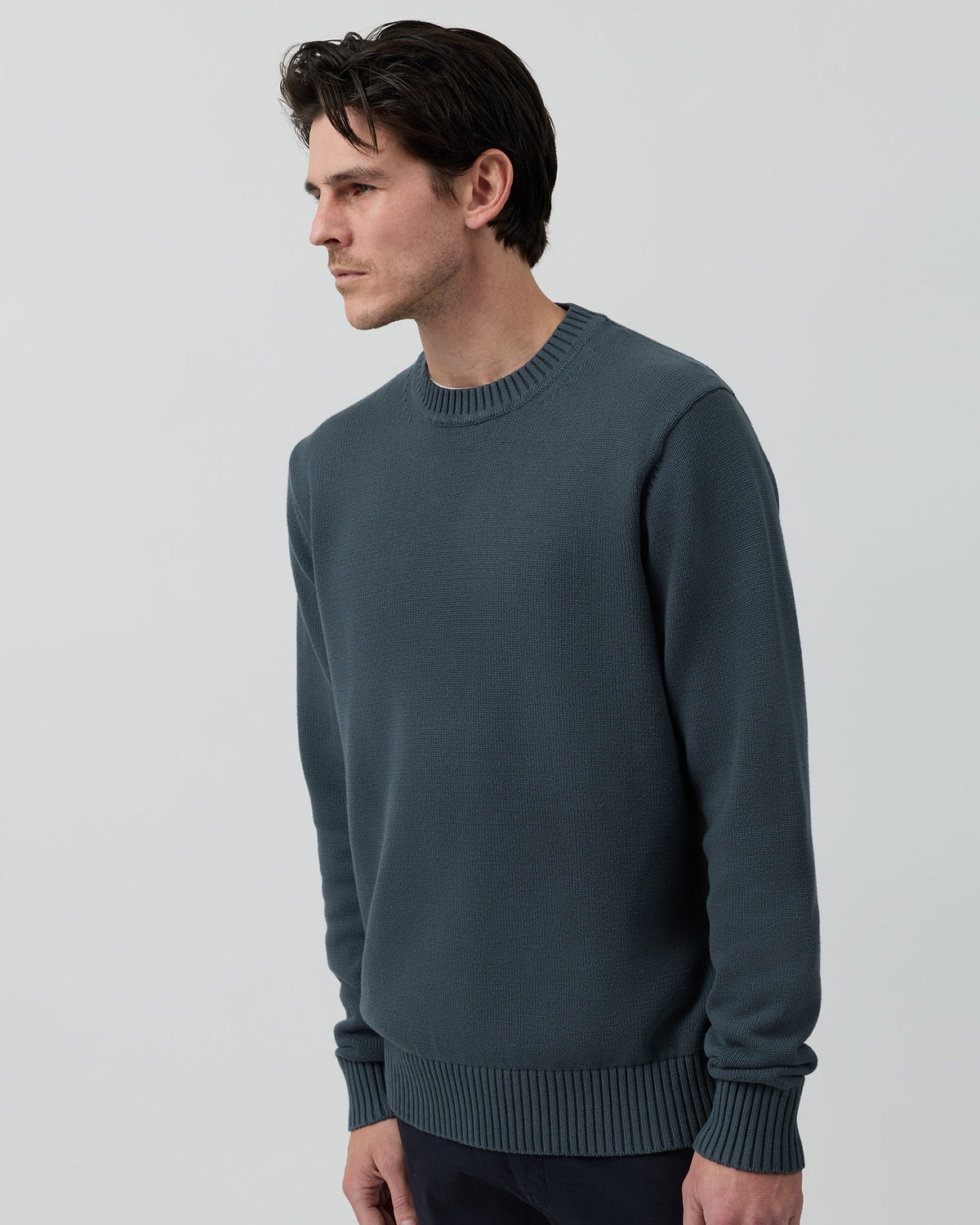 Angled side view of the Wayver ironstone 100% cotton crew neck knit showing the clean silhouette and premium cotton texture.