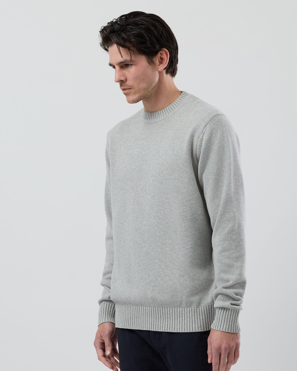 Angled side view of the Wayver light grey 100% cotton crew neck knit highlighting the refined silhouette and soft cotton texture.