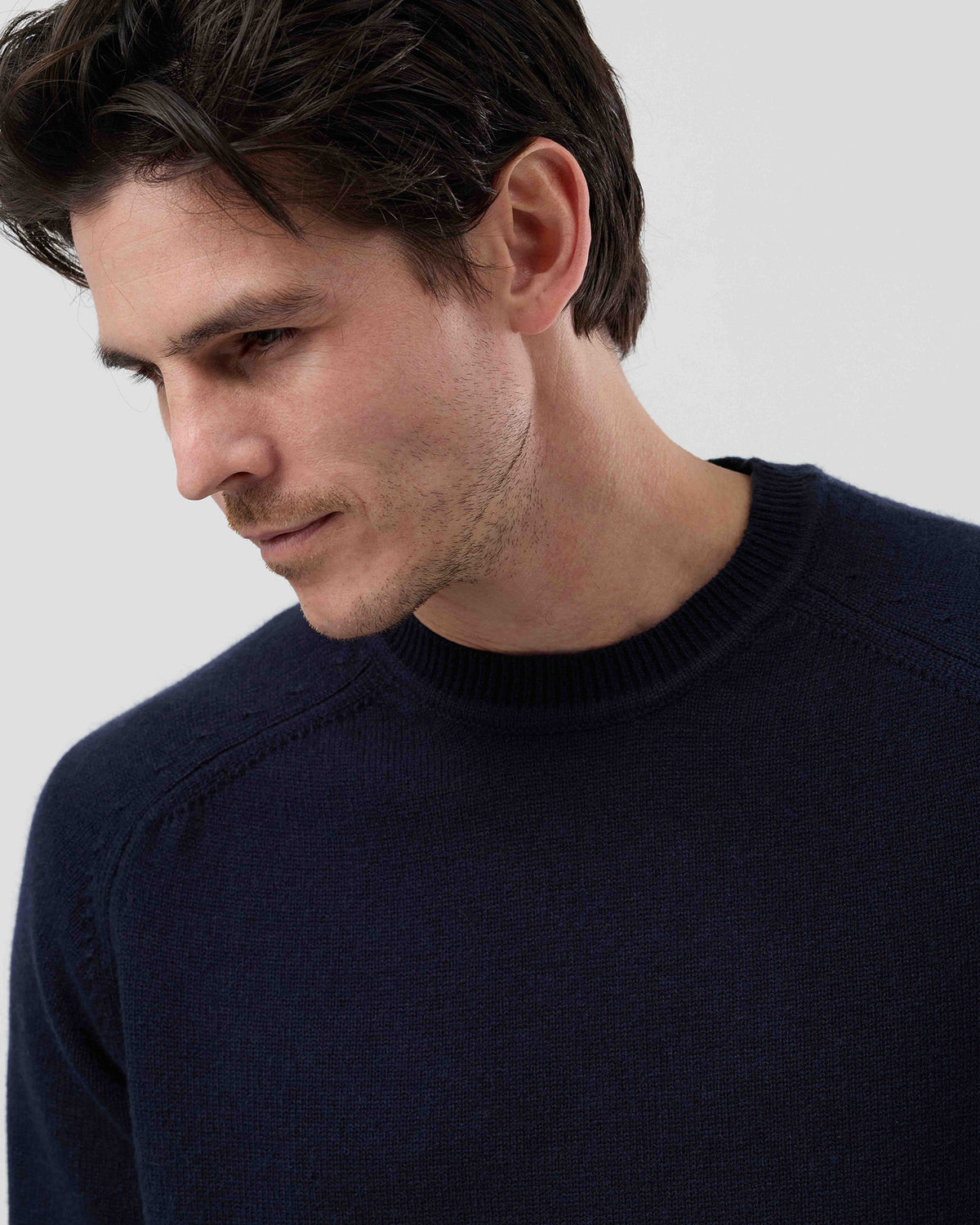 Close-up front view of a men's navy wool blend crew neck sweater highlighting the premium knit texture and refined finish.