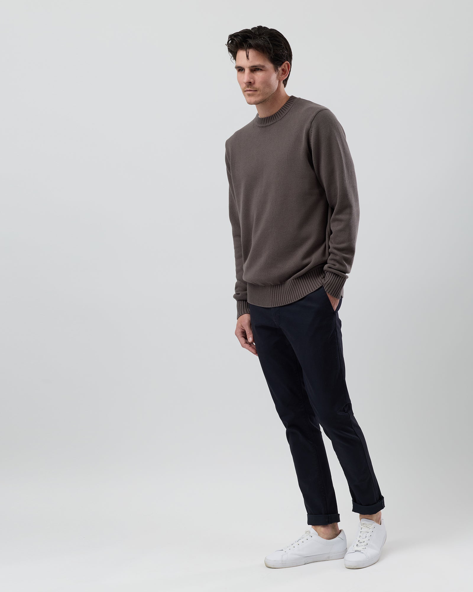 Male model wearing the Wayver Essential Cotton Crew Neck Knit in slate brown, front view showing the modern regular fit and slim sleeves.