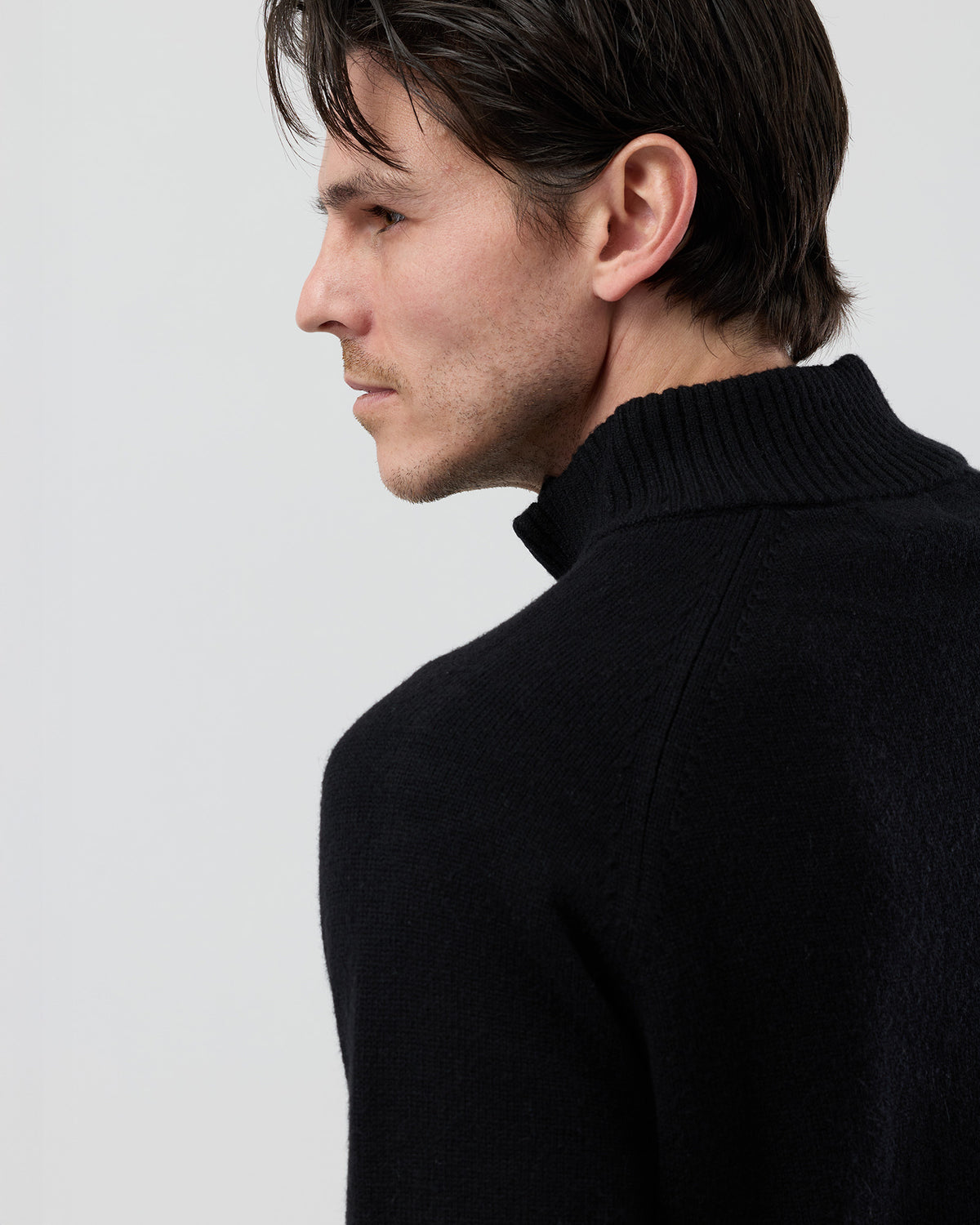 lose-up rear shoulder detail of the Wayver black wool blend knit showing the structured shoulder construction, stand collar shape and premium 9 gauge jersey knit texture.