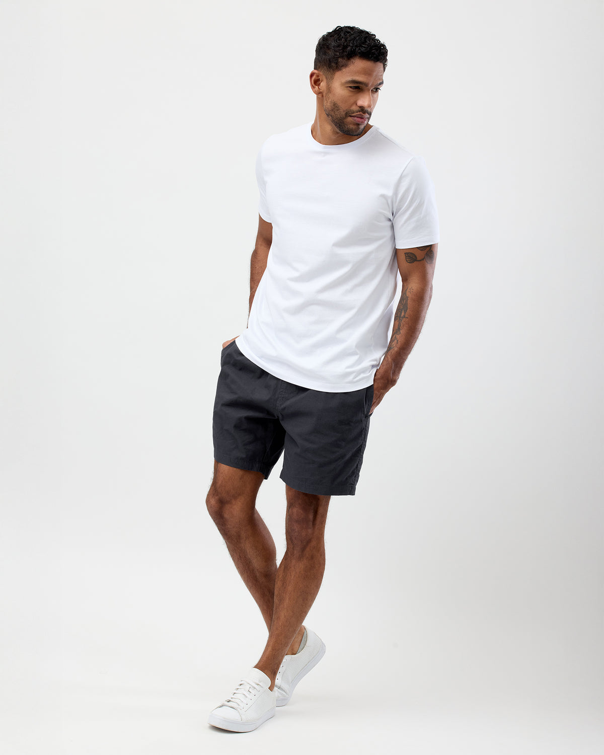 Summer style of a man wearing a white t-shirt and dark shorts on a white background