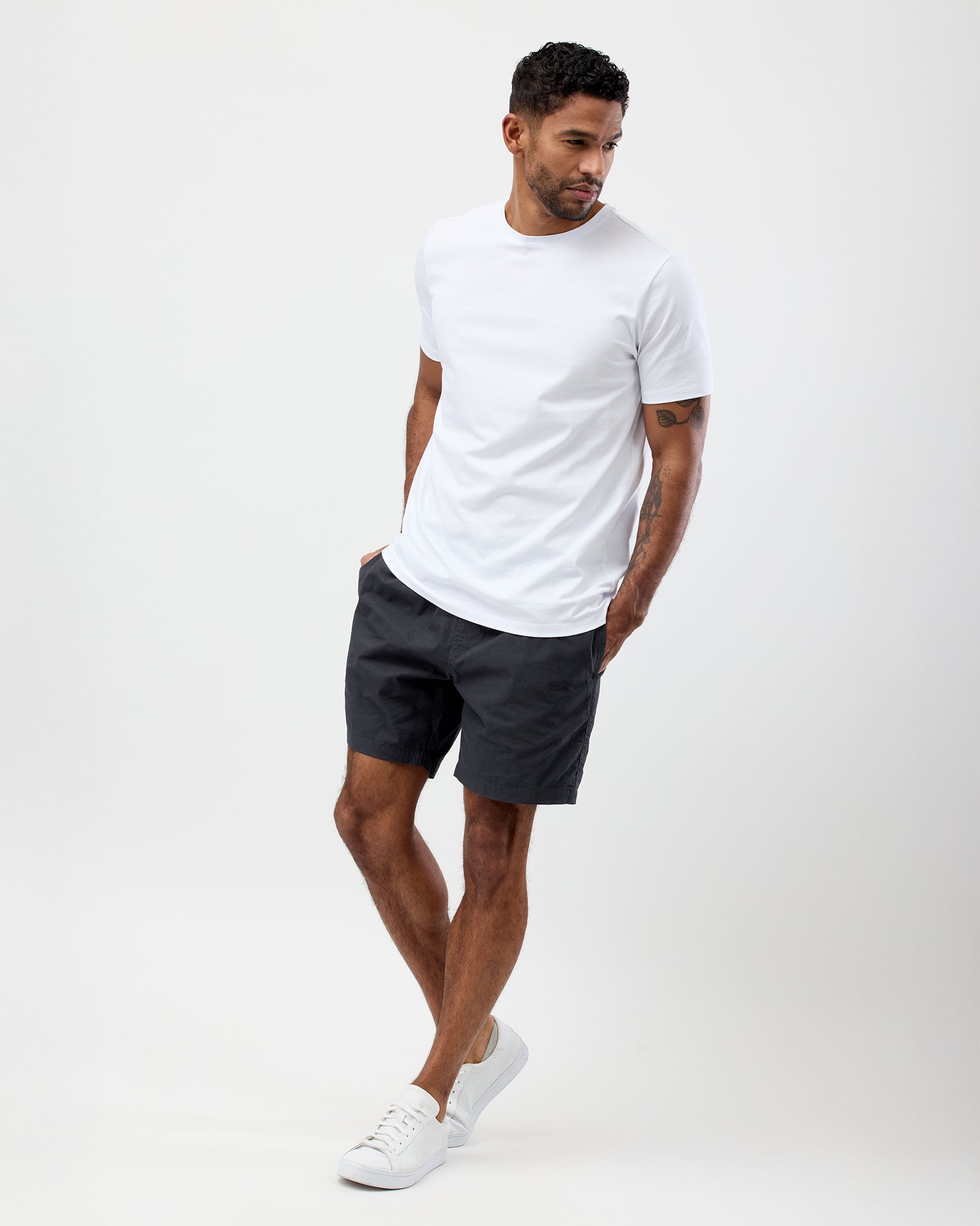 Summer style of a man wearing a white t-shirt and dark shorts on a white background