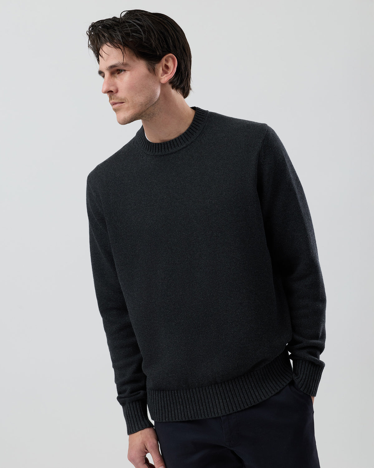 Male model wearing the Wayver Essential Cotton Crew Neck Knit in charcoal, front view showing the regular fit, slim sleeves and classic crew neckline.