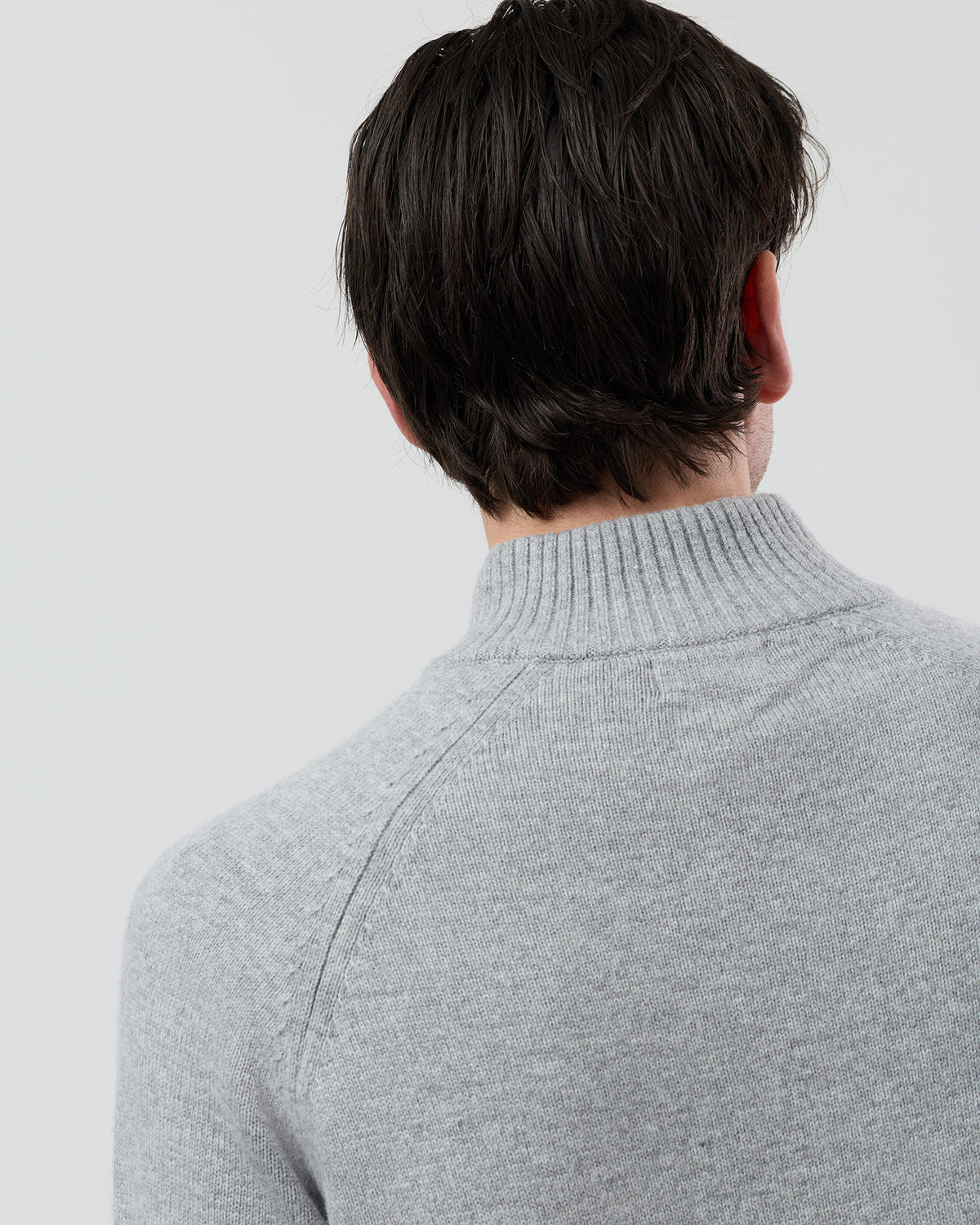 Close-up rear shoulder detail of the Wayver light grey wool blend knit showing the structured shoulder design, stand collar and premium 9 gauge jersey knit texture.