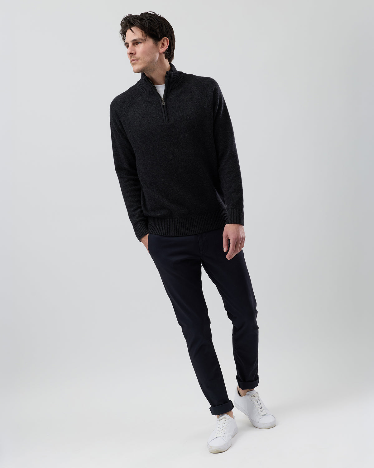 Full-length front view of a male model wearing the Wayver charcoal wool blend half zip knit styled with navy chinos on a grey background.
