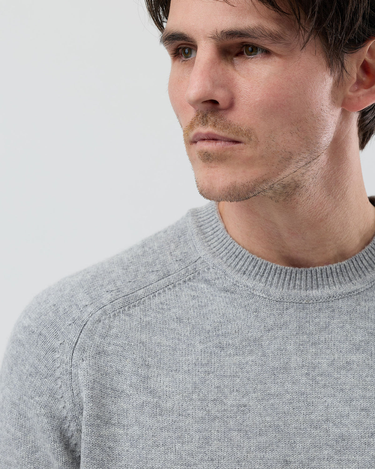 Close-up front view of a men's light grey wool blend crew neck jumper highlighting the premium knit texture and refined finish, by Wayver Originals.