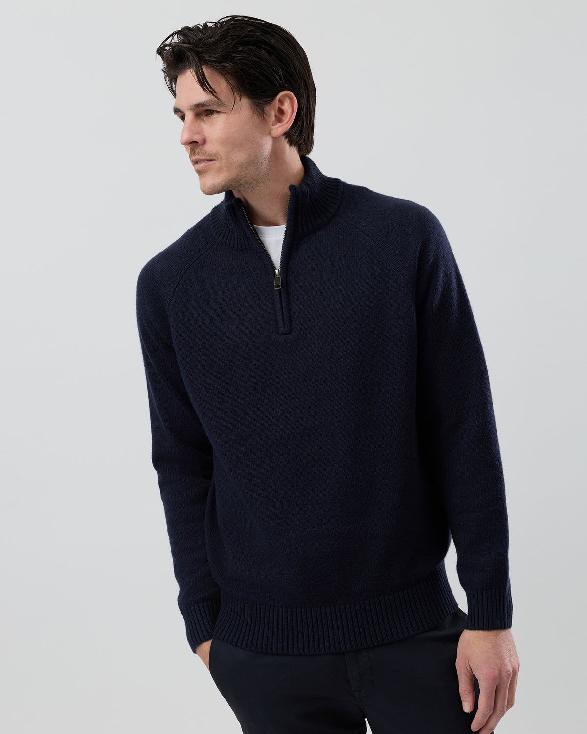 Male model wearing the Wayver navy wool blend half zip knit, front view showing the stand collar, regular fit and slim sleeves on a grey background.