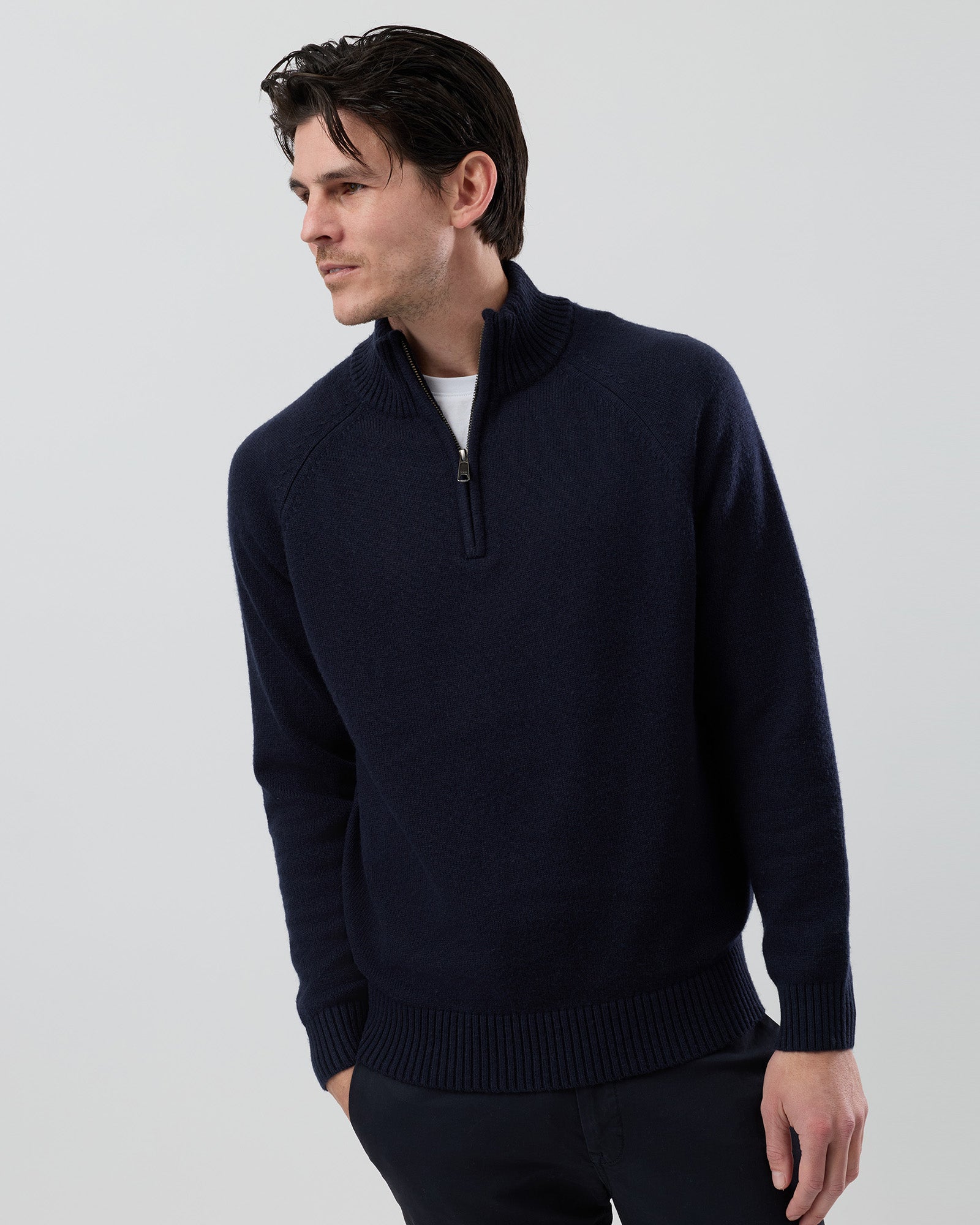 Male model wearing the Wayver navy wool blend half zip knit, front view showing the stand collar, regular fit and slim sleeves on a grey background.