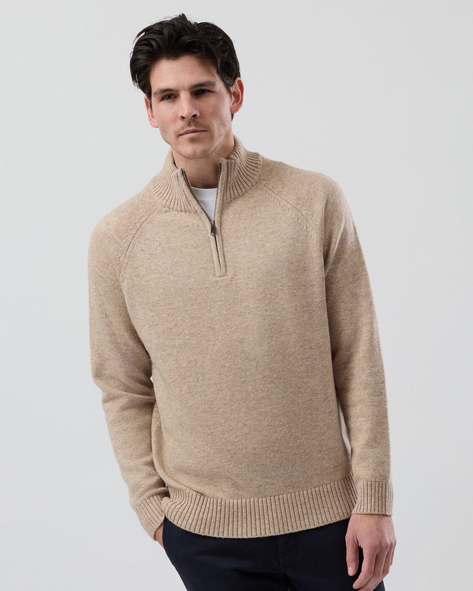 Male model wearing the Wayver oatmeal wool blend half zip knit, front view showing the stand collar, regular fit and slim sleeve design on a grey background.