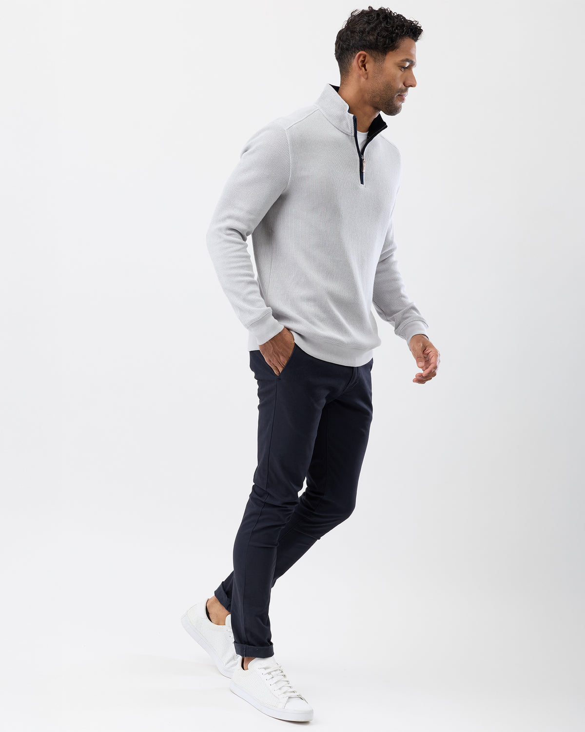 Model wearing stand collar sweater with chino pants and white sneakers - full body image