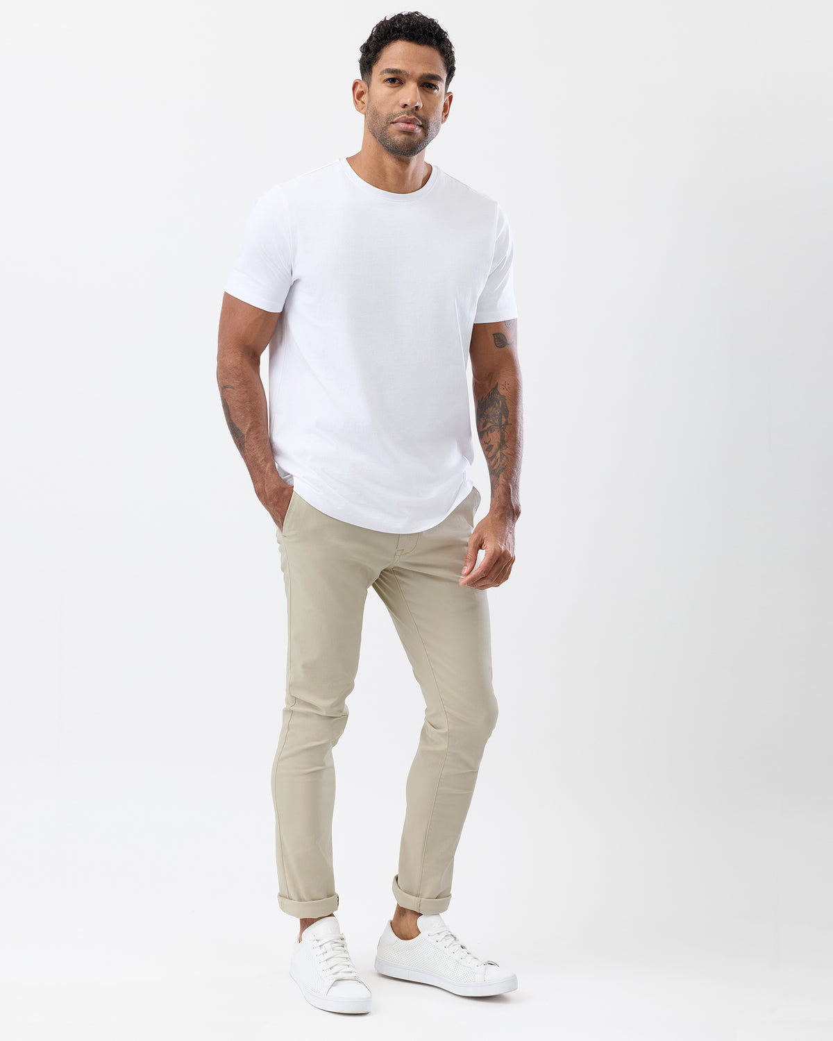 Side view of men's beige slim fit chinos showing the tapered leg, rolled hems and casual styling with a white t-shirt.