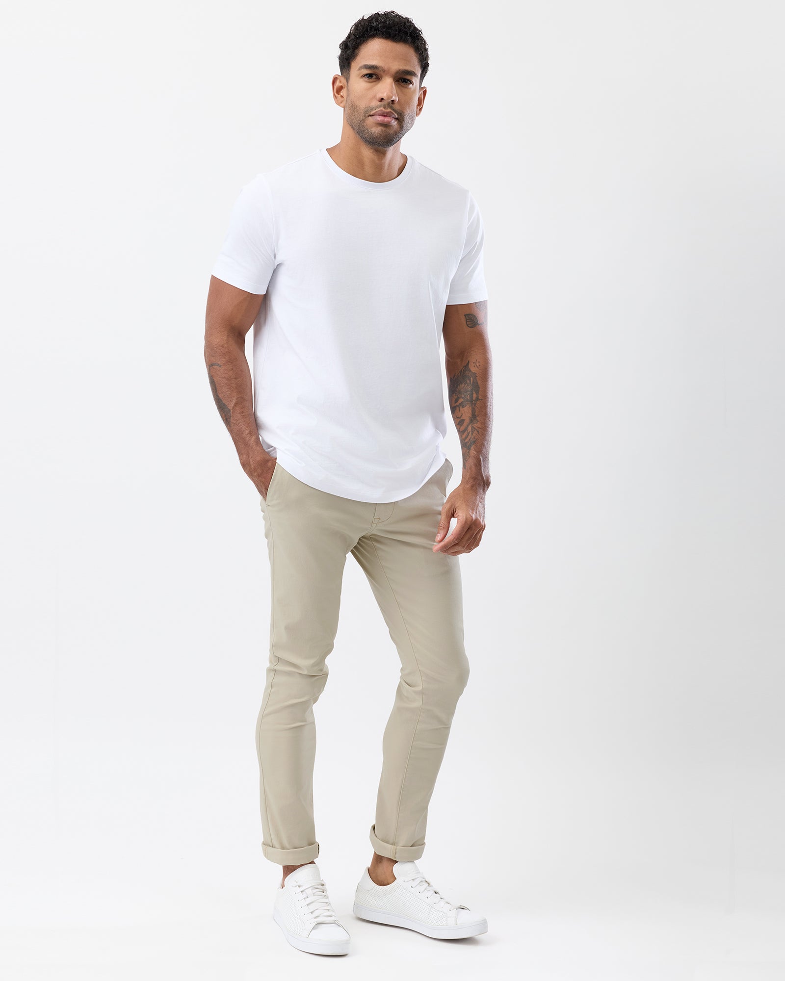 Side view of men's beige slim fit chinos showing the tapered leg, rolled hems and casual styling with a white t-shirt.