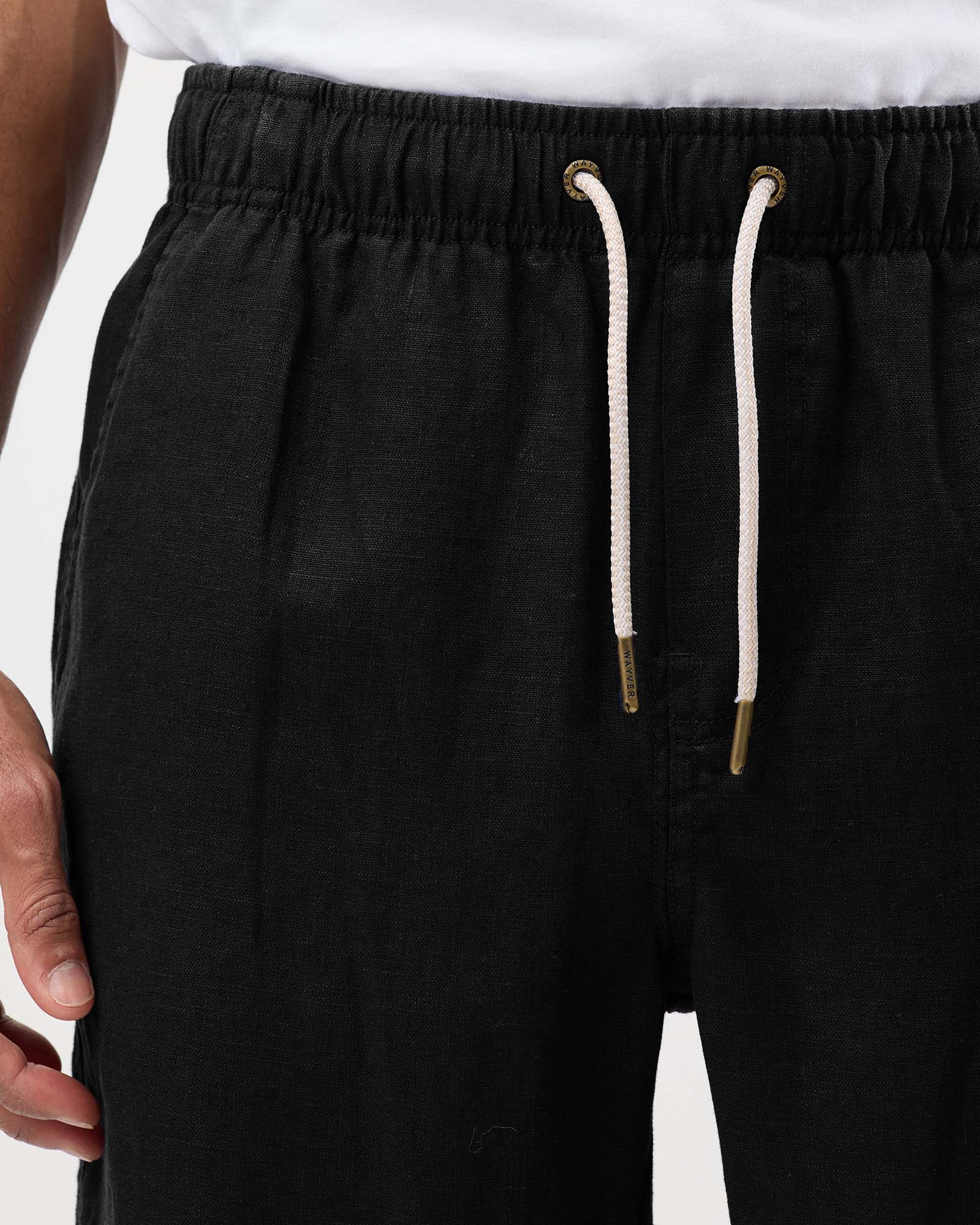 Black linen shorts with elastic waistband, drawstring and metal eyelet detail