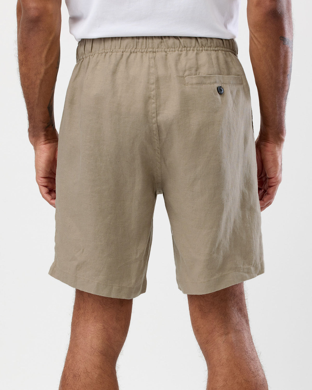Men's oat linen shorts back view with elastic waist and buttoned back pocket