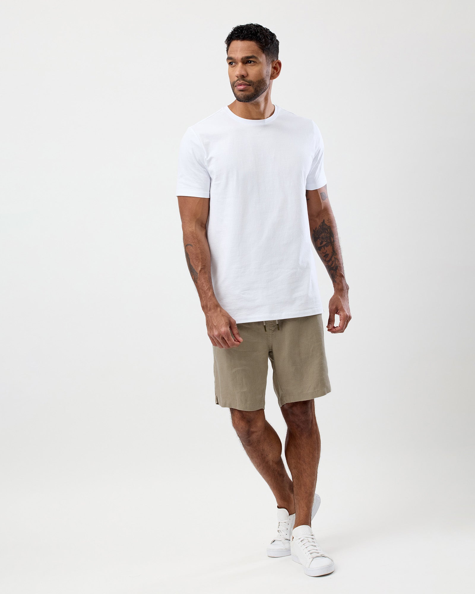 Men's oat linen shorts worn with a white T-shirt showing the relaxed fit