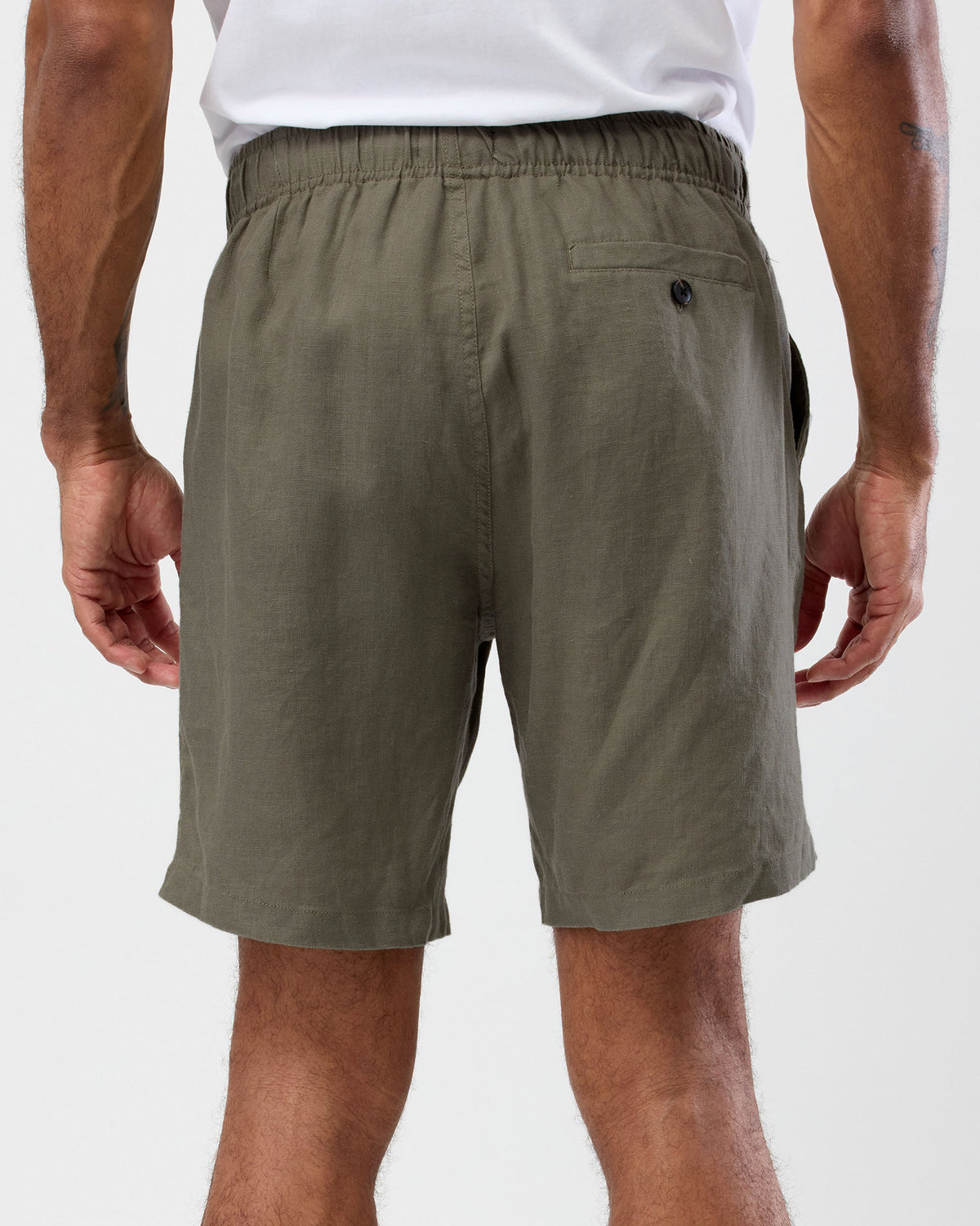 Men's olive linen shorts back view with elastic waist and buttoned back pocket, by wayver originals