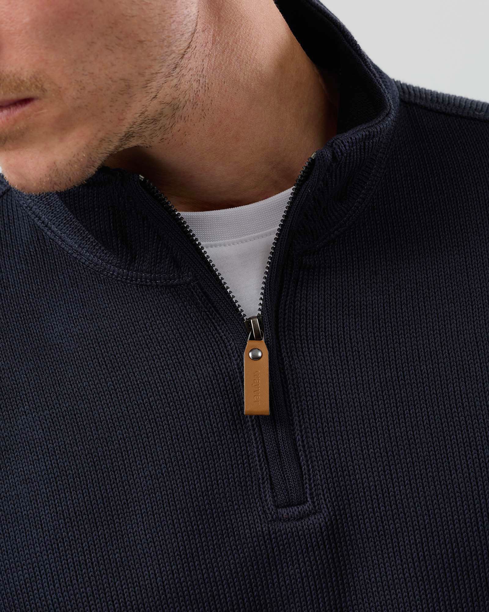 Close-up of navy French rib half zip knit jumper showing textured fabric, shoulder seam construction, back yoke stitching and ribbed collar.