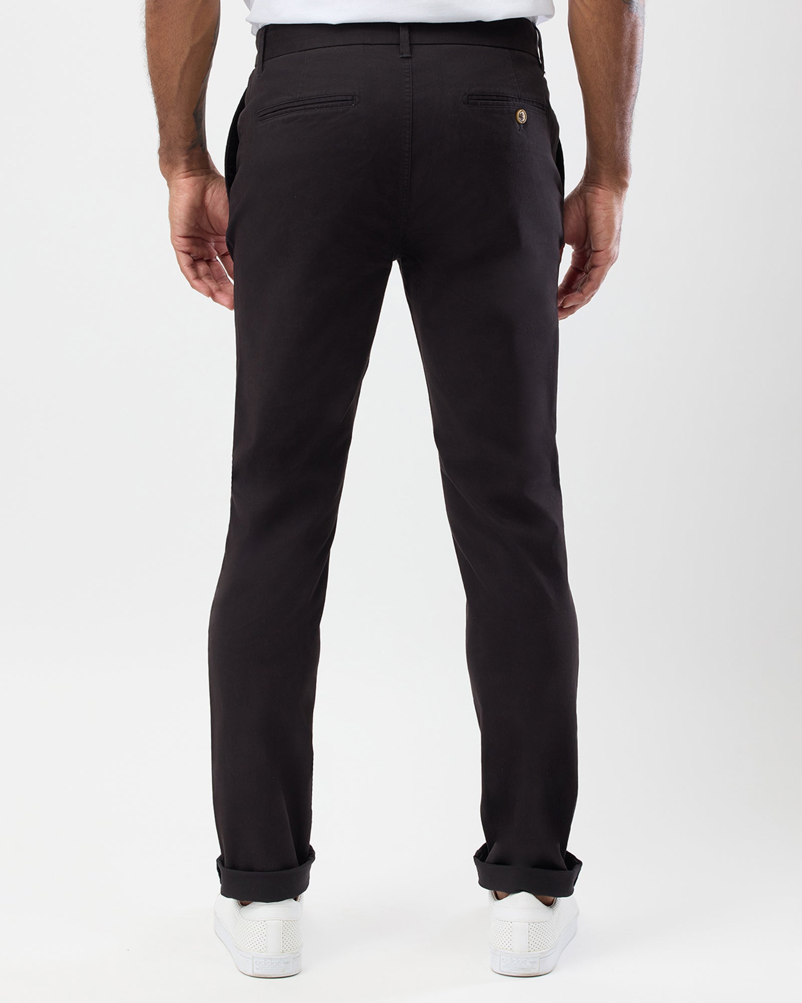 Rear view of men's black slim stretch chinos by Wayver Originals showing back welt pockets, button detail and slim tapered fit.