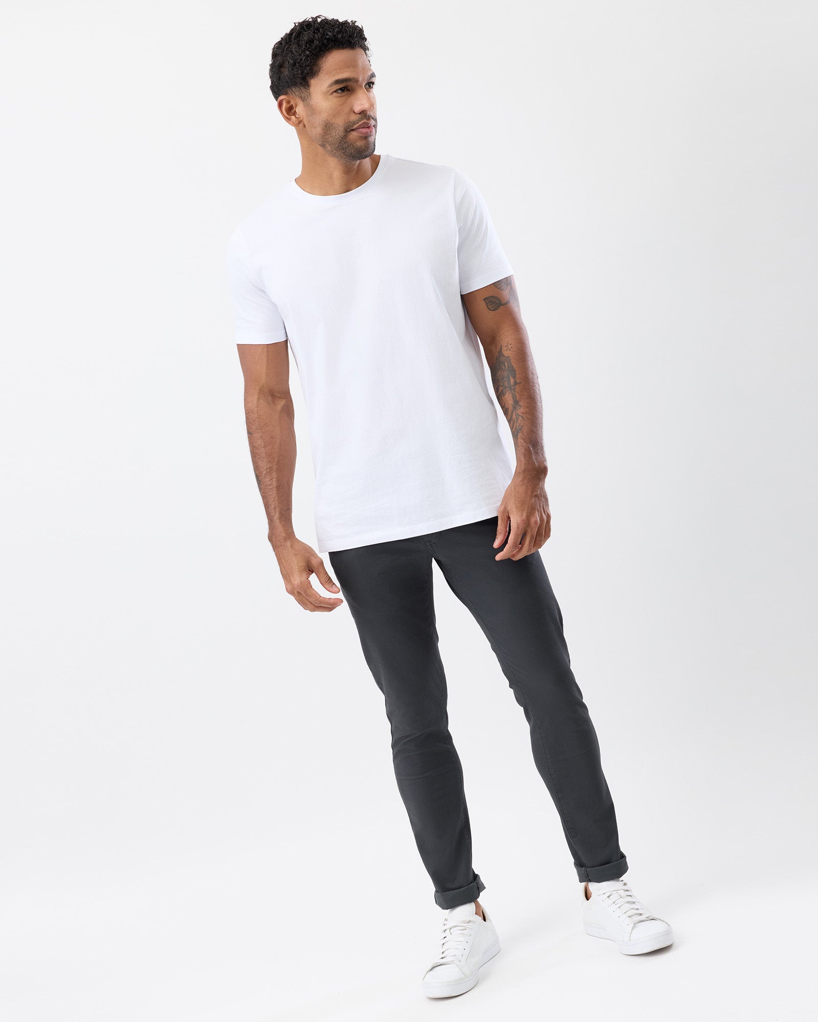Model wearing Wayver Originals charcoal slim stretch chinos made from 98% cotton 2% elastane, with a white tee, casual look.