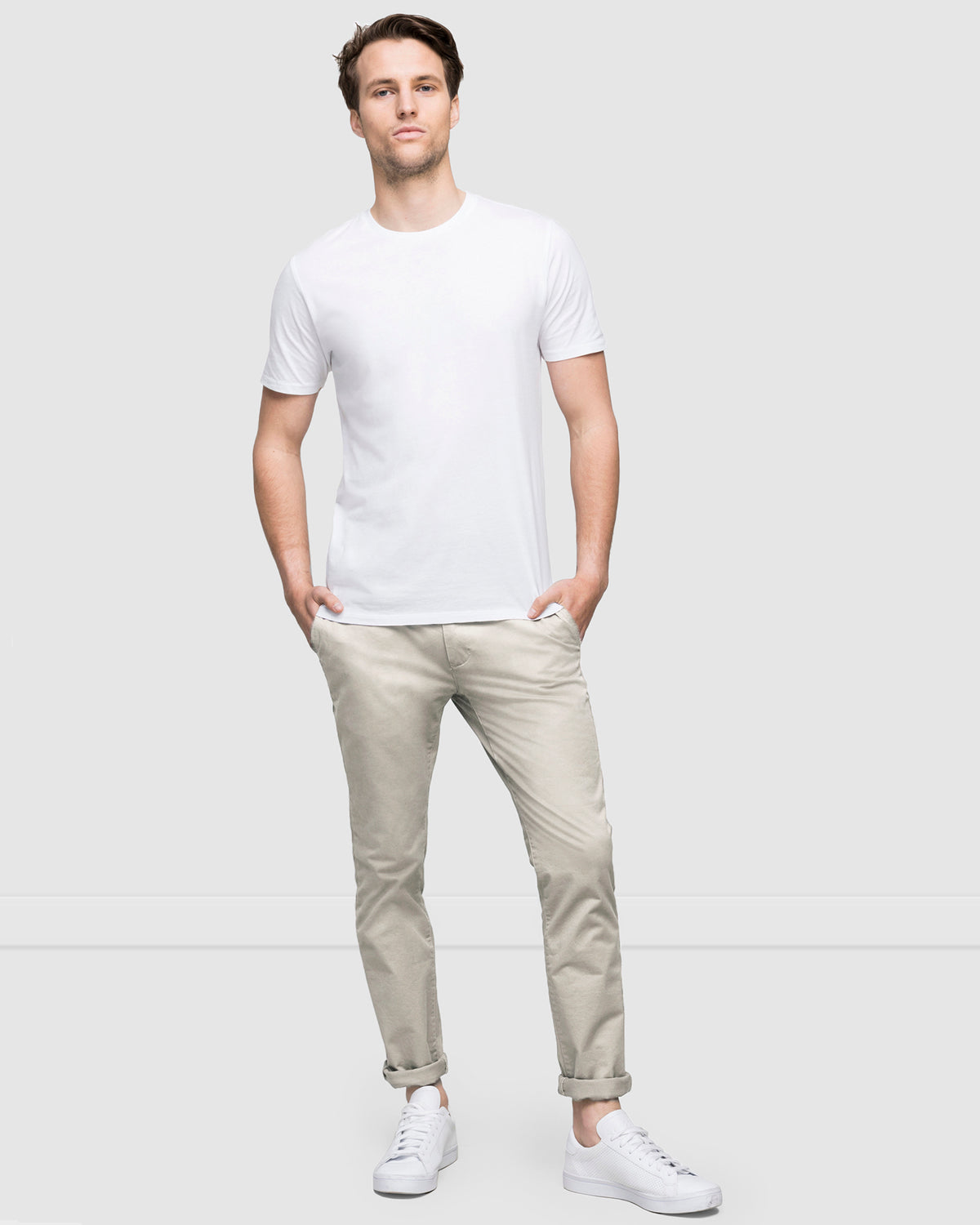 Men’s chinos worn rolled up at ankle, styled with white sneakers, by Wayver
