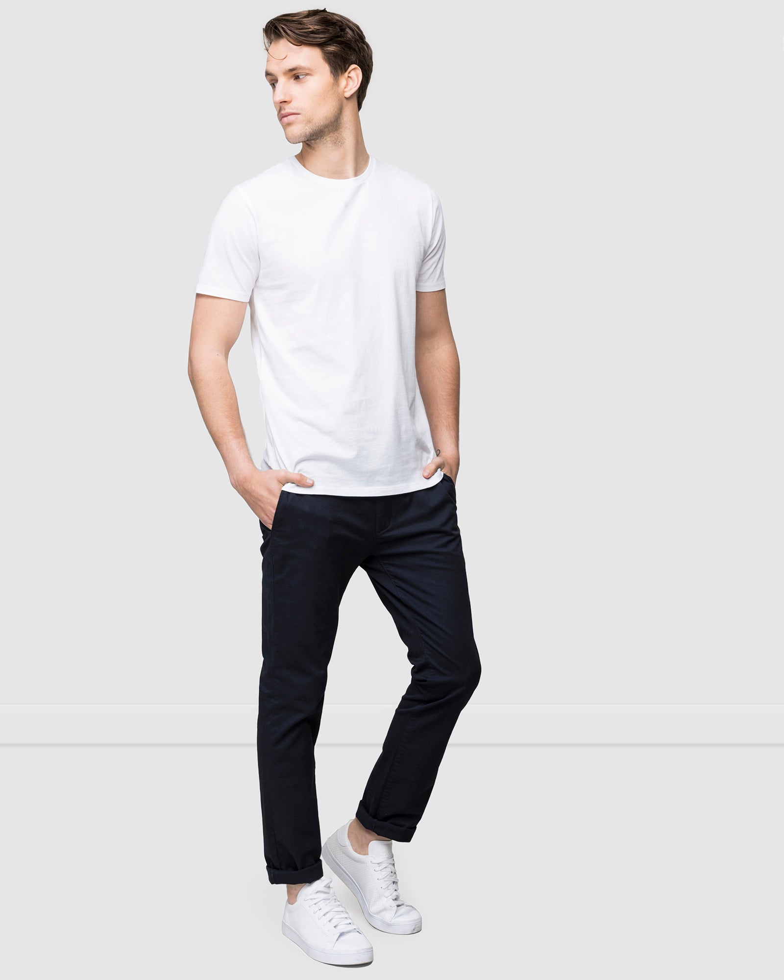 Slim fit men’s chinos styled for casual wear, navy colour worn with white t-shirt and white sneakers